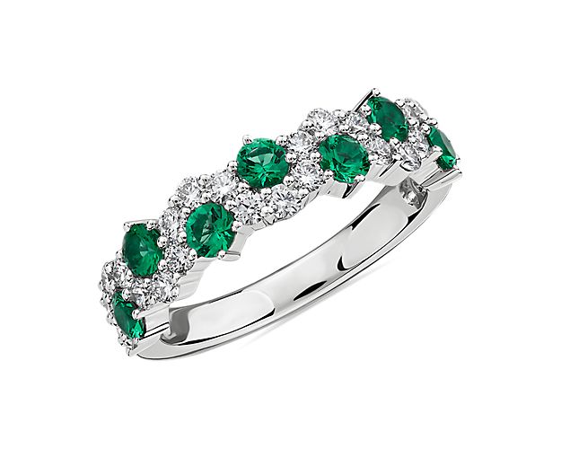 Captivating round emeralds emanate from a 14k white gold setting while a delicate garland of diamonds weaves around in an elegant curving line giving this ring a romantic contemporary look.
