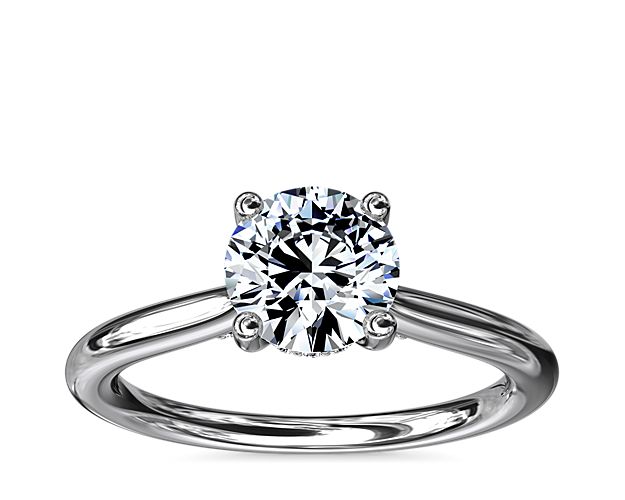 Classic from a bird's-eye view, this platinum solitaire has a delicate diamond profile and slight cathedral that put your center stone on display.