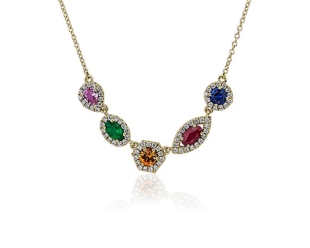 Bold and elegant, this multi-color necklace features various mixed-shaped gemstones including blue and pink sapphire, ruby, emerald, and orange garnet. These vibrant gemstones are framed with a sparkling halo of diamonds set in 18k yellow gold.