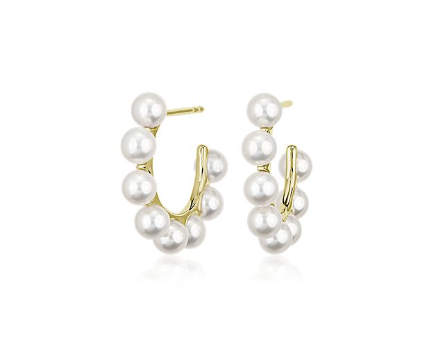 A string of delicate freshwater cultured pearls forms the minimal profile of these 14k yellow gold hoop earrings bringing timeless elegance to your ear stack.