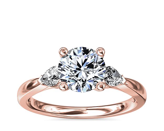 Pear-shaped side stones add a fancy-cut edge while an opulent 18k rose gold setting embraces your precious diamond.