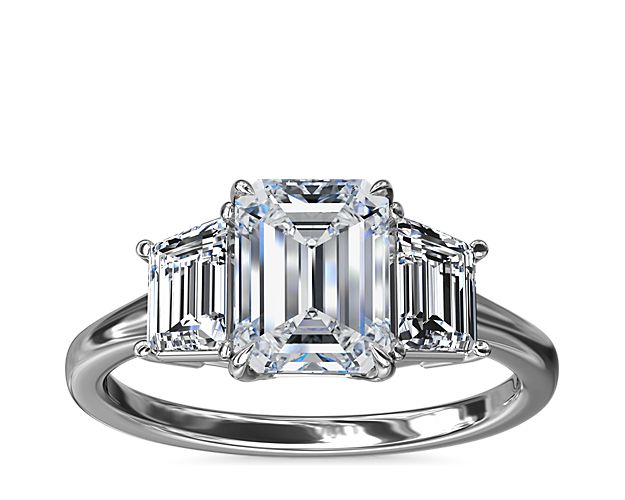 An enduring symbol of love, this platinum engagement ring showcases two trapezoid-shaped side stones framing your brilliant center stone creating a beautiful balance of symmetry and timeless style.