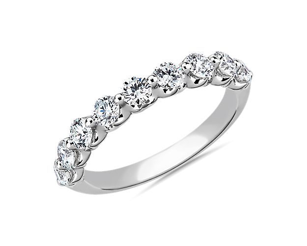 This exquisite diamond wedding ring features a row of seamless floating diamonds hand-set in a unique and low-profile platinum setting.