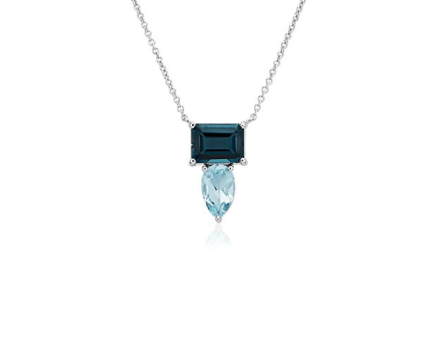 Two cool tones of blue topaz accent this pendant necklace crafted from 14k white gold and featuring a closely clustered shape.