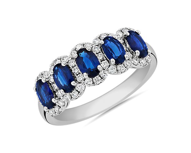 A spectacular array of oval-cut sapphires sparkle along this stunning anniversary band, with halos of diamonds emphasizing the beauty of each stone. The band features beautifully crafted 14k white gold design for a look of eternal luxury.