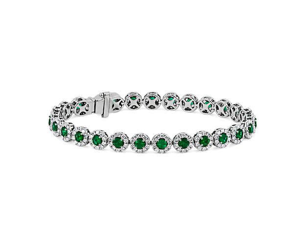 Get lost in the 360-degree sparkle of this 18k white gold bracelet designed with a string of round emeralds surrounded by delicate diamond halos that reflect a delightful display of color and light.