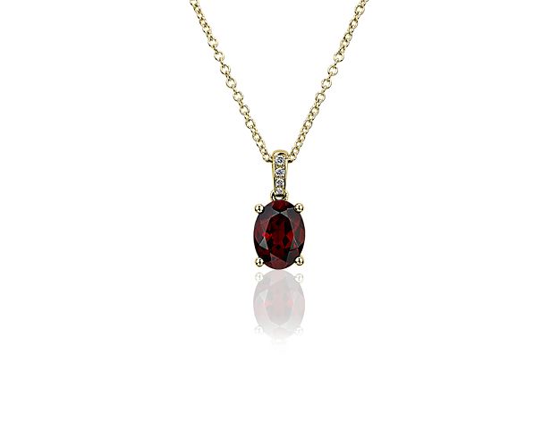 A rich red oval garnet sparkles in a beautifully contrasting yellow gold setting, making this pendant a stunning, yet simple piece. The four-prong setting holds the gemstone in elegantly classic style, and pavé-set diamonds add shimmer to the bail as it meets the cable chain.