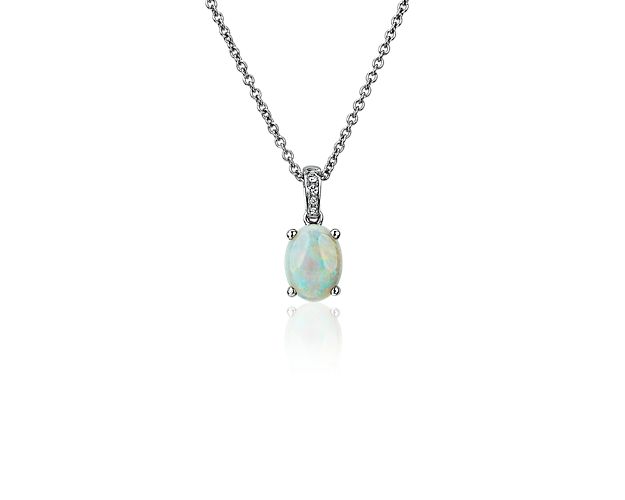 Opt for dreamy style as you accent your look with this pendant set with an ephemerally shimmering oval opal, accented by a trail of pavé-set diamonds along the bail. The four-prong setting and classic cable chain are crafted from white gold.