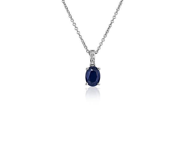 Let your eyes get lost in the soothing oval blue sapphire nestled in a four-prong white gold setting in this elegant pendant. A band of pavé-set diamonds anoints the bail with shimmering detail as it sweeps to meet the matching cable chain.