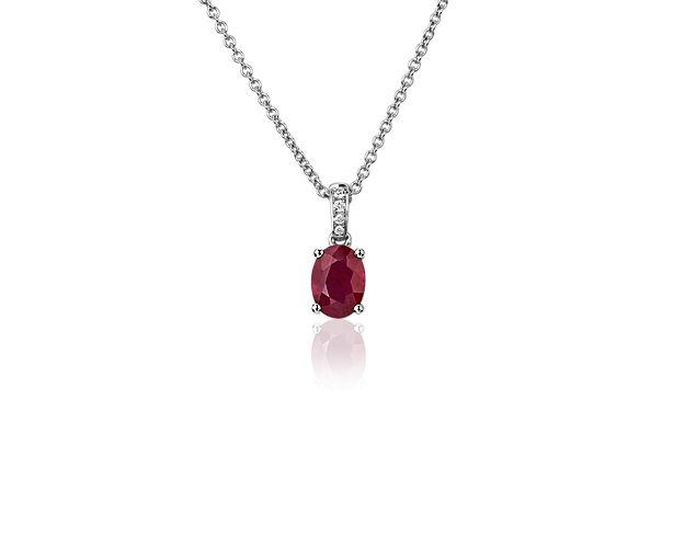 Lend a little passion to your look with this vivid red oval ruby pendant. The white gold four-prong setting holds the gemstone elegantly and features pavé-set diamonds along the bail. The classic cable chain is crafted in matching white gold.