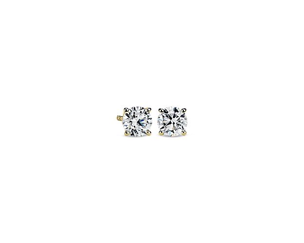 Radiant diamonds make the light dance across these timeless stud earrings crafted from warm yellow gold.