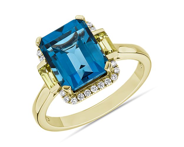 Find opulent hues of vivacious London blue topaz and two emerald cut peridots in this octagonal ring. Crafted with fine 14k yellow gold and accented with twenty two pave diamonds, this timeless piece offers show stopping brilliance for your collection.