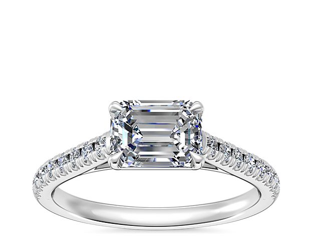 The east-west setting of the center stone updates this diamond engagement ring that's set in polished platinum. The classic design supports your choice of emerald, pear, marquise, or oval-cut diamond.