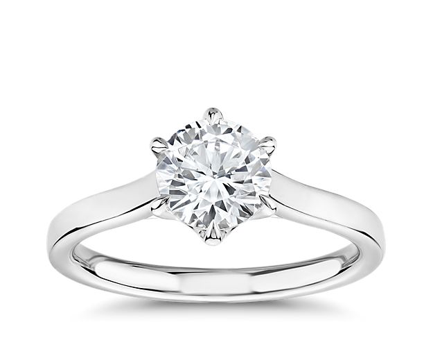 Featuring distinct detailing that flows effortlessly, this stunning platinum solitaire engagement ring showcases a brilliant round diamond in six-prong trellis setting.
