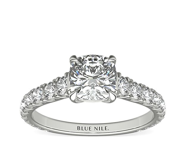 An expression of luxurious elegance, this platinum engagement ring highlights the center diamond that rests in a cathedral setting with scalloped pavé diamonds running down the sides of the band.