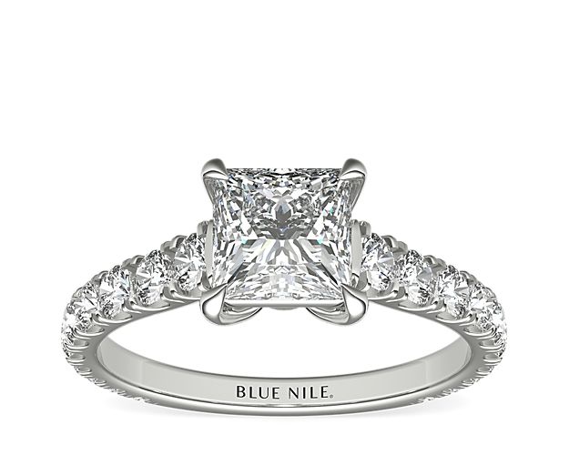 An expression of luxurious elegance, this platinum engagement ring highlights the center diamond that rests in a cathedral setting with scalloped pavé diamonds running down the sides of the band.