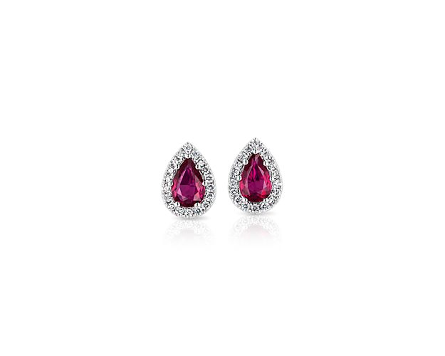Pure fiery red and sparkling white come together in these beautiful stud earrings. Two pear-cut rubies dazzle from within halos of diamond pavé to complete your glamorous look.
