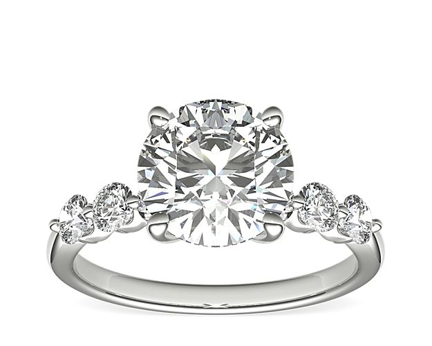 An expression of luxurious elegance, this platinum engagement ring sparkles with excellent-cut sidestones with hearts & arrows complementing the center stone.