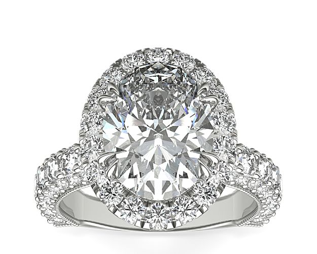 A gorgeous setting for the oval center stone of your choice. This platinum diamond engagement ring showcases a majestic pavé halo crown and an exceptional triple-row band featuring a striking asscher-cut diamond channel. This setting is custom made to fit your beautiful center stone.