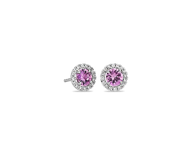 We've added a bit of color to a classic style. These pink sapphire and diamond halo are crafted in bright 18k white gold and feature round pink sapphires surrounded by sparkling halos of micropavé diamonds. Their petite size makes them a great everyday jewelry option.