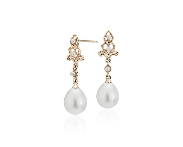 Perfect for the vintage-loving woman, these freshwater cultured pearl drop earrings feature luminous teardrop-shaped white pearls accented by mini seed pearls. The delicately crafted 14k yellow gold settings showcase filigree openwork and milgrain details with post closures for pierced ears.