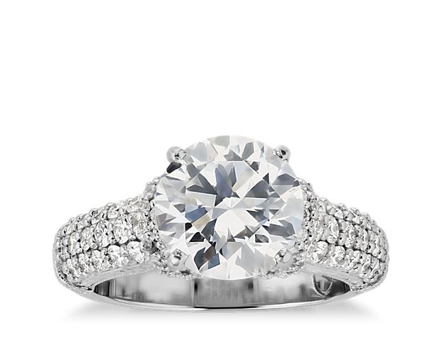 This majestic diamond engagement ring features three rows of brilliant pavé diamonds and an intricately draped diamond collar to enhance your center diamond. This setting is custom made to fit your beautiful center stone.
