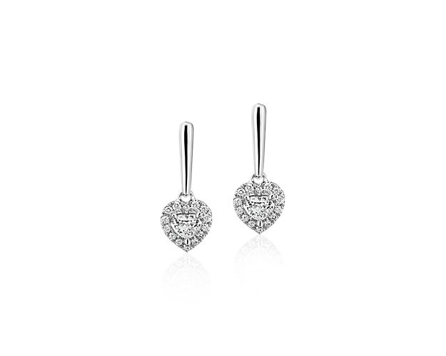For a look that epitomizes love, these 14k white gold drop earrings each feature a single symbolic heart-shaped diamond surrounded by a halo of 14 shimmering round-cut diamonds.