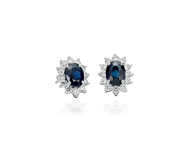 Deep blue sapphires make a colorful statement in these classic sapphire and diamond stud earrings. Two faceted oval sapphire gemstones are encircled by 18k white gold halos of prong-set, round brilliant-cut diamonds. The total weight of the two sapphires is approximately 2 1/3 carats, just the right size to get noticed.
