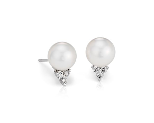 Three brilliant cut diamonds accent a lustrous South Sea cultured pearl in these classic 18k white gold earrings.
