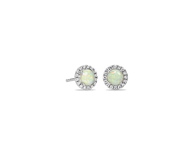 These delicate opal and diamond halo earrings are an ideal choice for someone who wants to add a bit of color to a classic style. Crafted in bright 18k white gold, these gemstone stud earrings feature round white opals surrounded by sparkling halos of micropavé diamonds. Their petite size makes them a great everyday jewelry option.