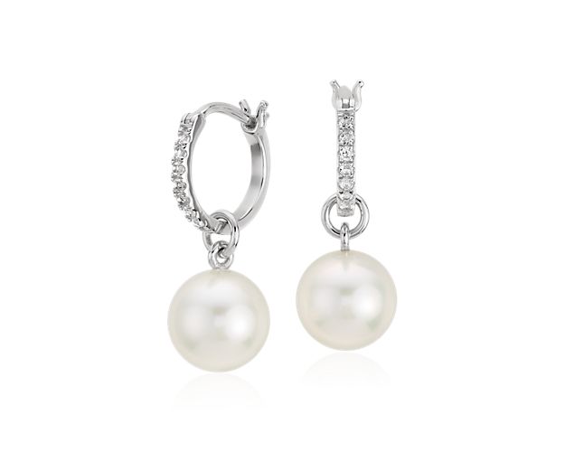 Luminous and sparkling, these white topaz and pearl hoop earrings are crafted in sterling silver with freshwater cultured pearl drops complemented by petite round topaz gemstones. This earring can be worn with or without the pearl, as the pearl can slide off the earring and be worn as a white topaz hoop earring.