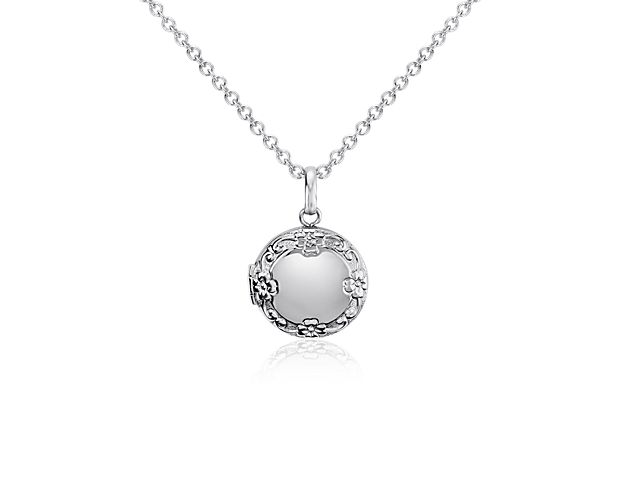 Endearing in every way, this children's round locket is crafted in sterling silver and a matching cable chain necklace. The floral pendant opens to hold your favorite pictures.