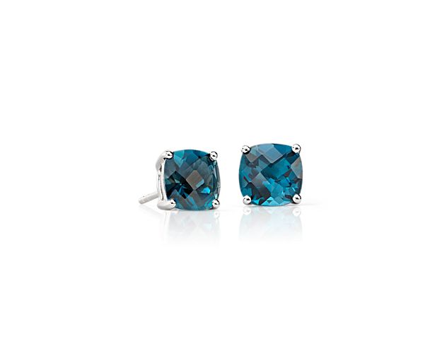 Deep London blue topaz gemstones, set in polished four-prong sterling silver stud earrings, add a touch of color to your everyday style. The unique, faceted cushion shape of the gemstones offers a modern twist on the classic solitaire stud.