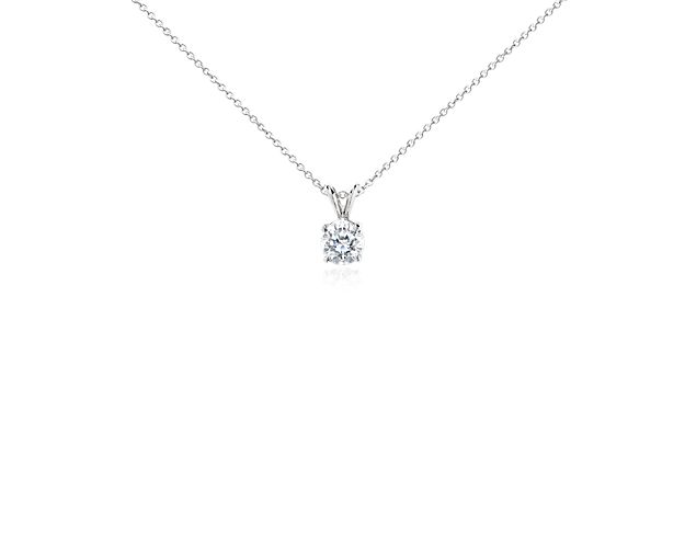 This round diamond is delicately held by four prongs and suspends from a platinum cable chain. 1 1/2 carat total diamond weight.