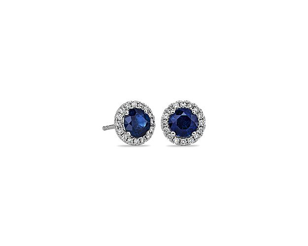 These deep blue sapphire and diamond halo earrings are an excellent choice for someone who wants to add a bit of color to a classic style. Crafted in bright 18k white gold, these gemstone stud earrings feature round sapphires surrounded by sparkling halos of micropavé diamonds. Their petite size makes them a great everyday jewelry option.
