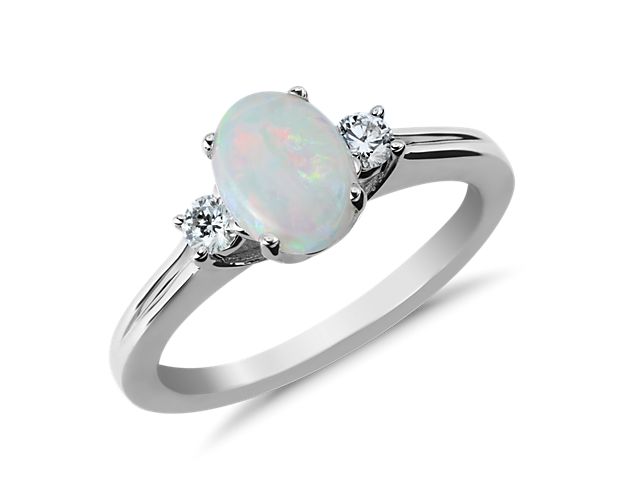 Opal's natural play of color is accentuated by the sparkle of two brilliant diamonds in this oval gemstone ring set in 18k white gold. While perfect for special occasion wear, opals are a softer gemstone and not recommended for daily wear.