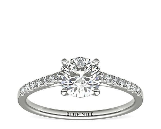 Elegant and graceful, this engagement ring setting showcases pavé-set diamonds in a slim platinum cathedral ring design to frame your center diamond. Setting includes 1/6 carat total diamond weight.