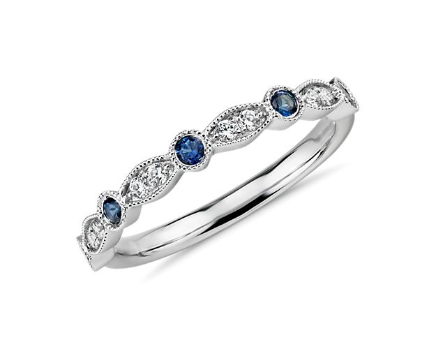 This elegant diamond and sapphire wedding band is stunning in its vintage allure, featuring a motif of alternating round and marquise shapes and dainty milgrain detailing in 14k white gold.