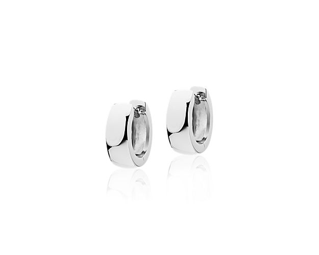 These hoop earrings are crafted in 14k white gold with a wide domed design, high-polish finish, and secured with a hinged snap back closure.