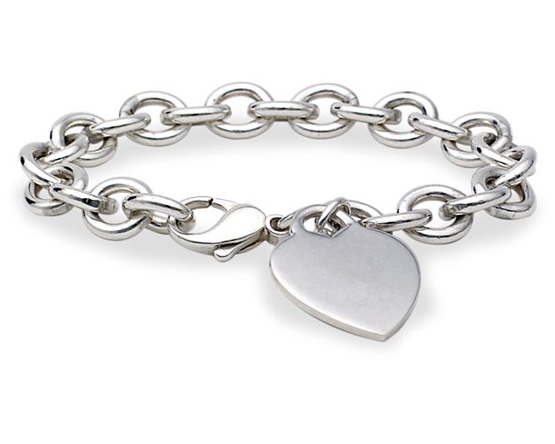 A classic sterling silver heart-tag bracelet that makes a no-fail gift. Substantial rolo links encircle the wrist in shine, while a secure lobster-claw clasp keeps it in place. The polished sterling silver heart tag dangles near the clasp and is engravable with initials, a monogram, a special someone's name, or a sweet saying for a personal touch.