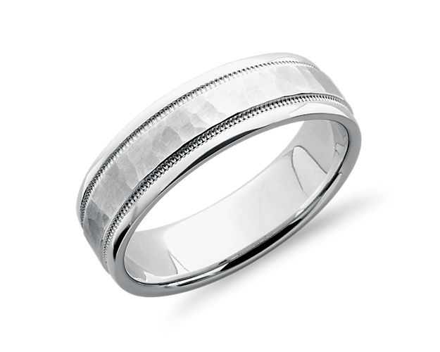 This platinum wedding ring is meticulously crafted with an artistic hammered finish, inset milgrain borders, and brightly polished edges. Its softly rounded inner edges allow for comfortable regular wear.