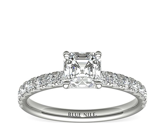 Demure and sparkling, this diamond engagement ring features round diamonds pavé-set in 18k white gold to complement your choice of diamond.