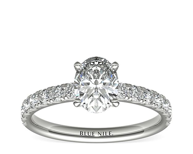 Demure and sparkling, this diamond engagement ring features round diamonds pavé-set in 18k white gold to complement your choice of diamond.