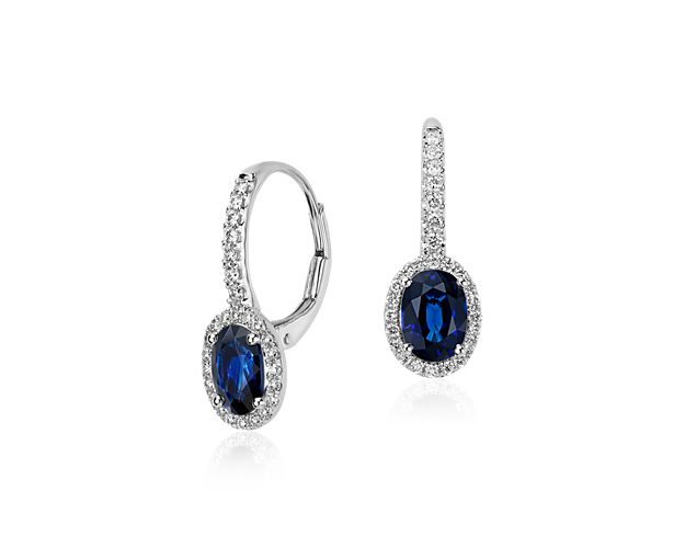 Oval sapphires of midnight blue are framed by glittering halos of micropavé set brilliant diamonds in these timeless drop earrings crafted of 14k white gold.