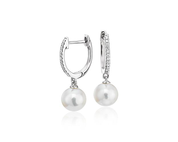 Luminous and sparkling, these Freshwater cultured pearl and diamond hoop earrings are a perfect day-to-night pair. Two round white pearls are suspended from petite, pavé diamond hoops with a hinged back closure crafted in polished 14k white gold.