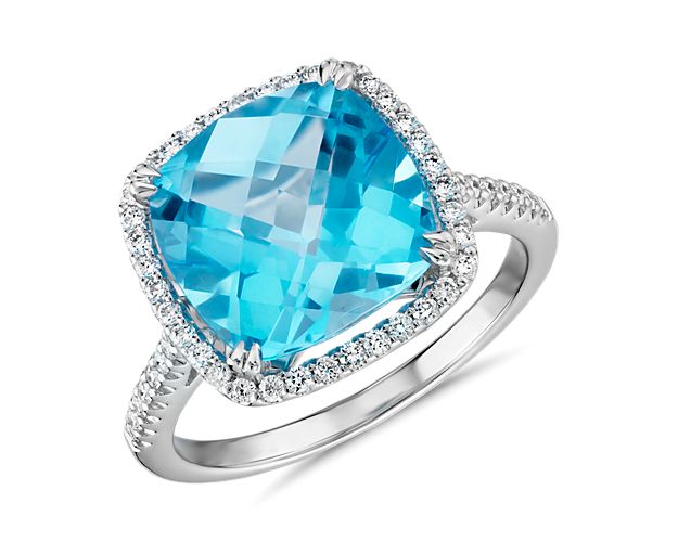 This gorgeous 14k white gold cocktail ring features a cushion-cut Swiss blue topaz surrounded by a halo of tiny pavé-set diamonds. An effortless upgrade to your accessory wardrobe.