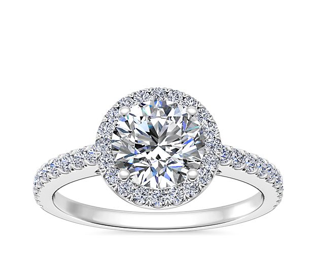 Create a breathtaking moment with this decadent engagement ring, showcasing a diamond laden shank and halo, deftly framed against immaculate 14k white gold.