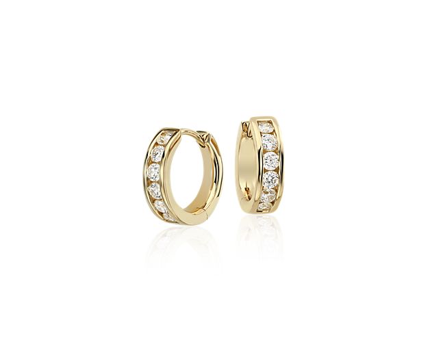 There's no wrong way to wear these mini diamond hoop earrings. Crafted in striking 14k yellow gold, they feature channel-set round brilliant-cut diamonds and a smooth hinged closure. Their petite size and simple styling make them a great choice for everyday wear. Diameter of hoop measures 1/2 Inch.