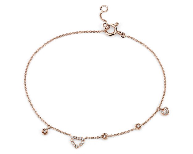 Drops of brilliance, this mini diamond heart bracelet features asymmetrical diamond charms stationed along a 14k rose gold cable chain.