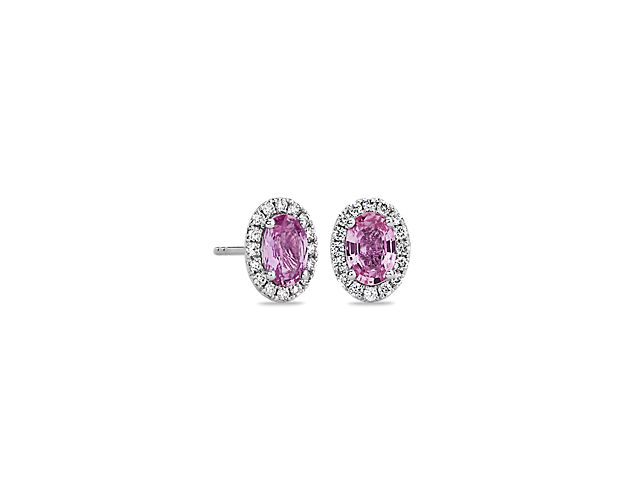 Vivid pink sapphires are surrounded by sparkling halos of micropavé-set round brilliant diamonds in these elegant earrings, framed in 14k white gold.